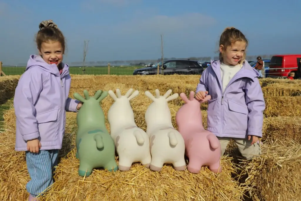 Twee kinderen met springkoeien op strobalen tijdens Kijk bij de boer 2025